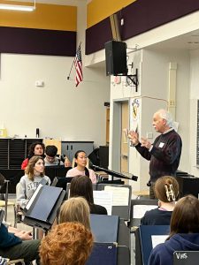 Teacher and alumnus Jerry Shedd discusses his original composition with band students.