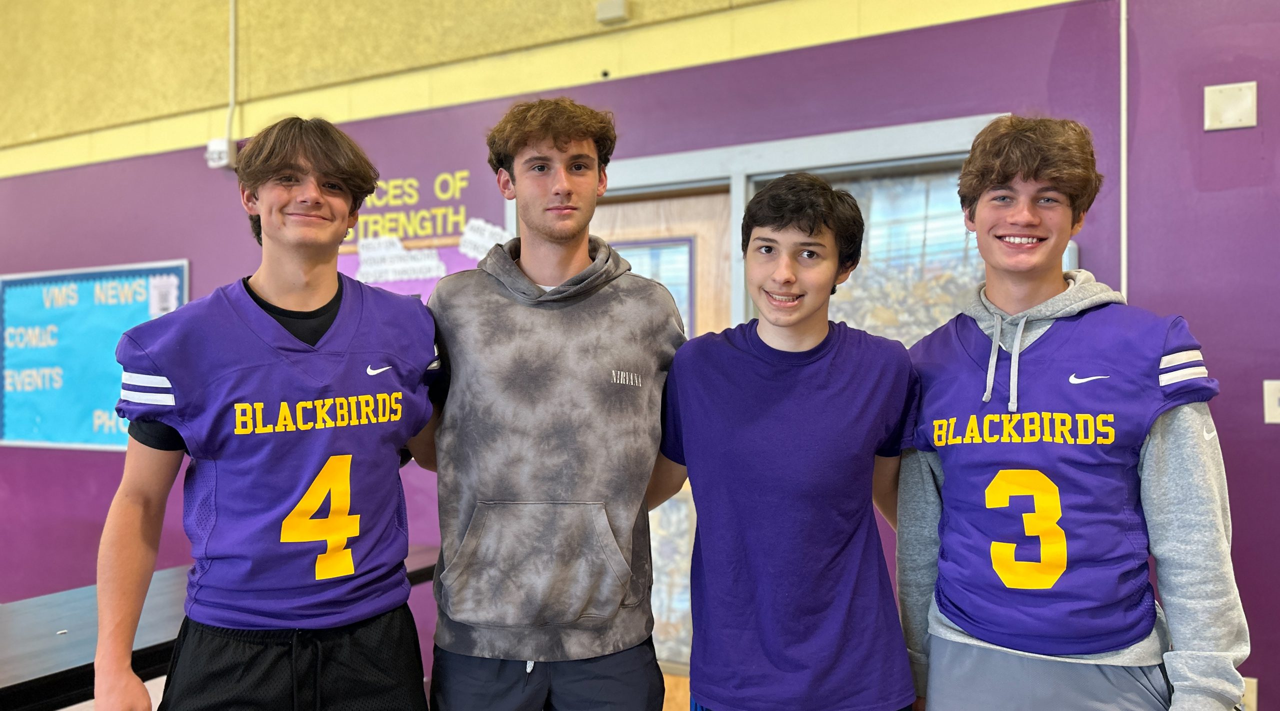 Students wearing Voorheesville branded clothing stand together with arms around each other.