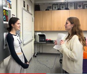 Two high school students standing in classroom.