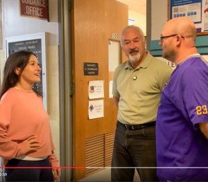 Three adults in conversation in hallway outside of counseling department.